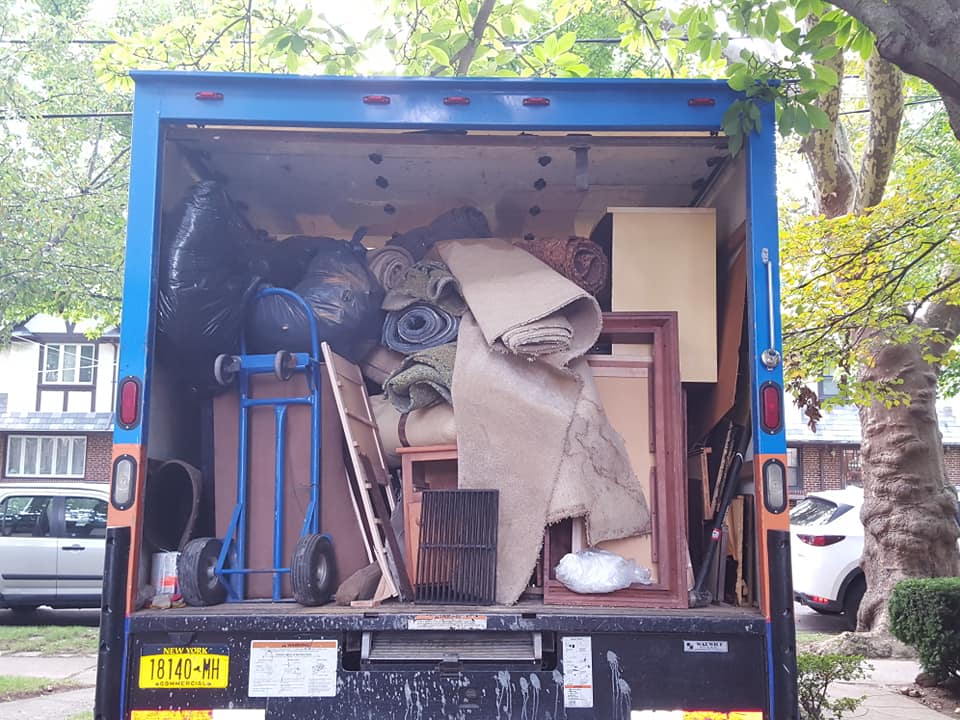 Junk removal truck fully loaded with furniture, carpet, and debris after estate cleanout in Westchester NY